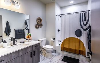 a bathroom with a shower and a sink and a toilet